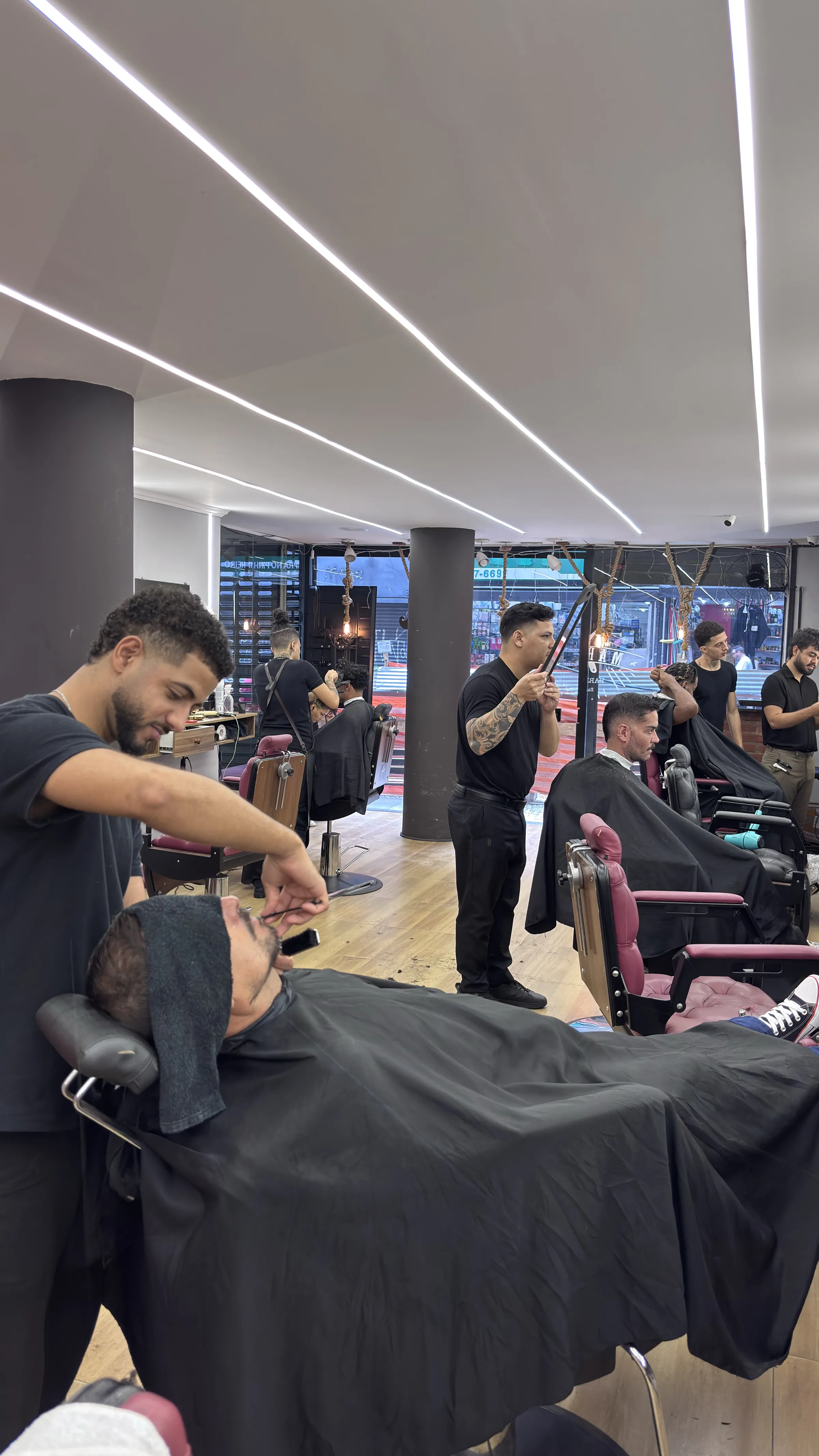 Barbeiro fazendo o acabamento da barba de um cliente