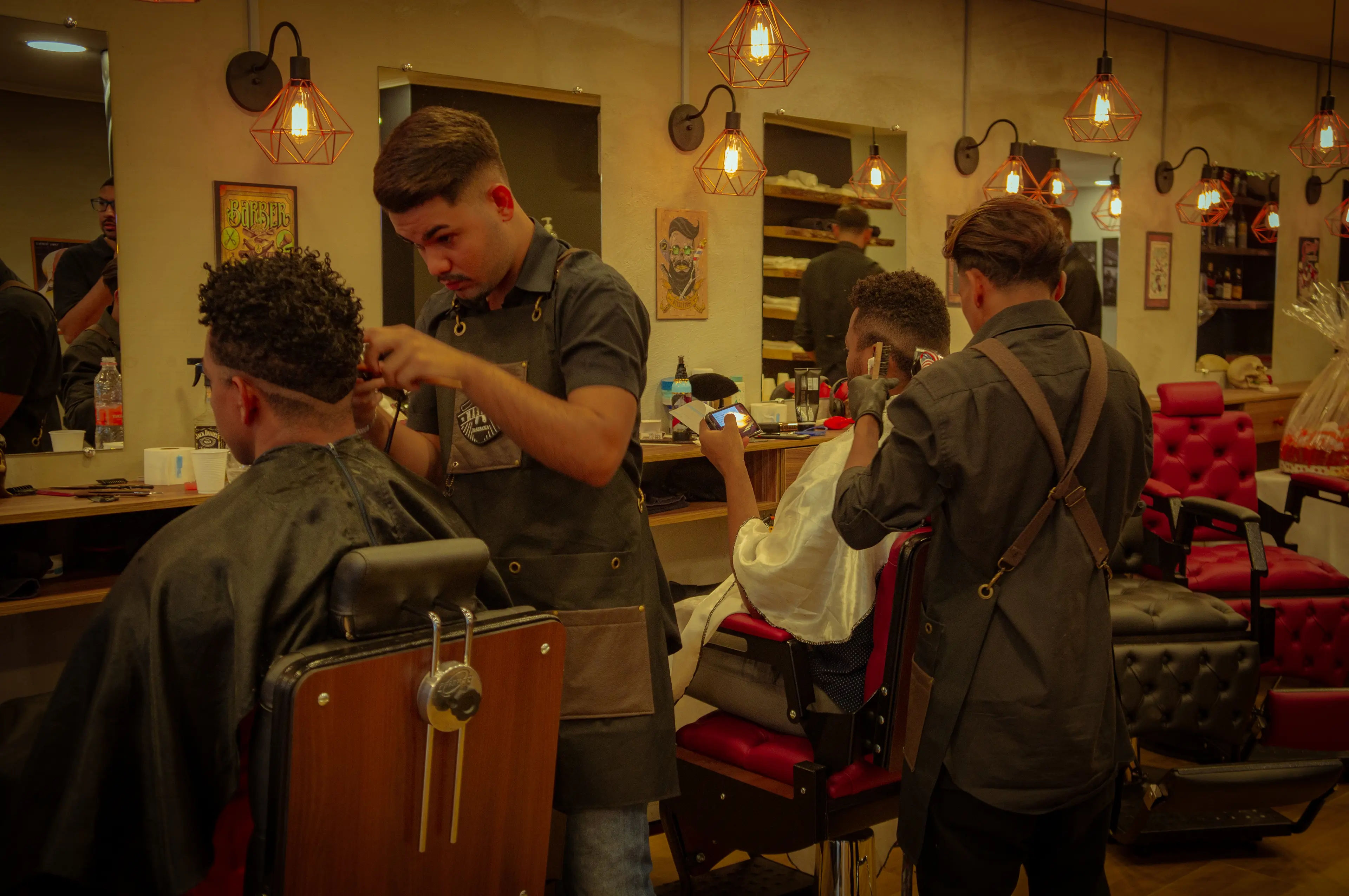 Barbeiros da Barbearia Marconi atendendo clientes no salão de corte